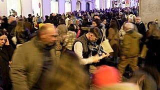 ARQUIVO: Multidões passam por um artista a tocar violino no bairro do Chiado, na baixa de Lisboa, na noite de sábado, 23 de dezembro de 2023.