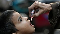  عامل صحي يُعطي لقاح شلل الأطفال لطفل في كراتشي، باكستان، 8 كانون الثاني/يناير 2024.
