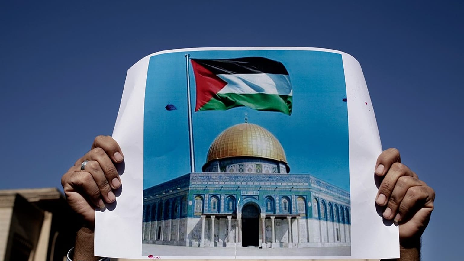  رجل يحمل لافتة عليها العلم الفلسطيني وصورة للمسجد الأقصى، خلال مظاهرة في القاهرة، مصر، الجمعة 8 ديسمبر/كانون الأول 2017.  