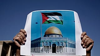 رجل يحمل لافتة عليها العلم الفلسطيني وصورة للمسجد الأقصى، خلال مظاهرة في القاهرة، مصر، الجمعة 8 ديسمبر/كانون الأول 2017.  