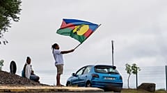 Eine Frau schwenkt am Mittwoch, den 15. Mai 2024, in Noumea, Neukaledonien, eine Flagge der Kanak und der Sozialistischen Nationalen Befreiungsfront (FLNKS).