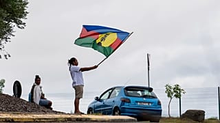 Egy nő lobogtatja a Kanak és Szocialista Nemzeti Felszabadítási Front (FLNKS) zászlaját az új-kaledóniai Noumeában 2024. május 15-én, szerdán.