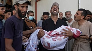 رجل فلسطيني يحمل جثة طفله ، الذي قتل في غارة جوية عسكرية إسرائيلية على غزة ، في مستشفى الشفاء في مدينة غزة ، السبت 12 يوليو / تموز 2025. 