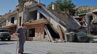 رجل يمر بمنزل دمر خلال الحرب الأهلية السورية في قرية بيت جين ، جنوب سوريا ، حيث قامت القوات الإسرائيلية بغارة قبل الفجر ، الخميس 12 يونيو / حزيران 2025. 