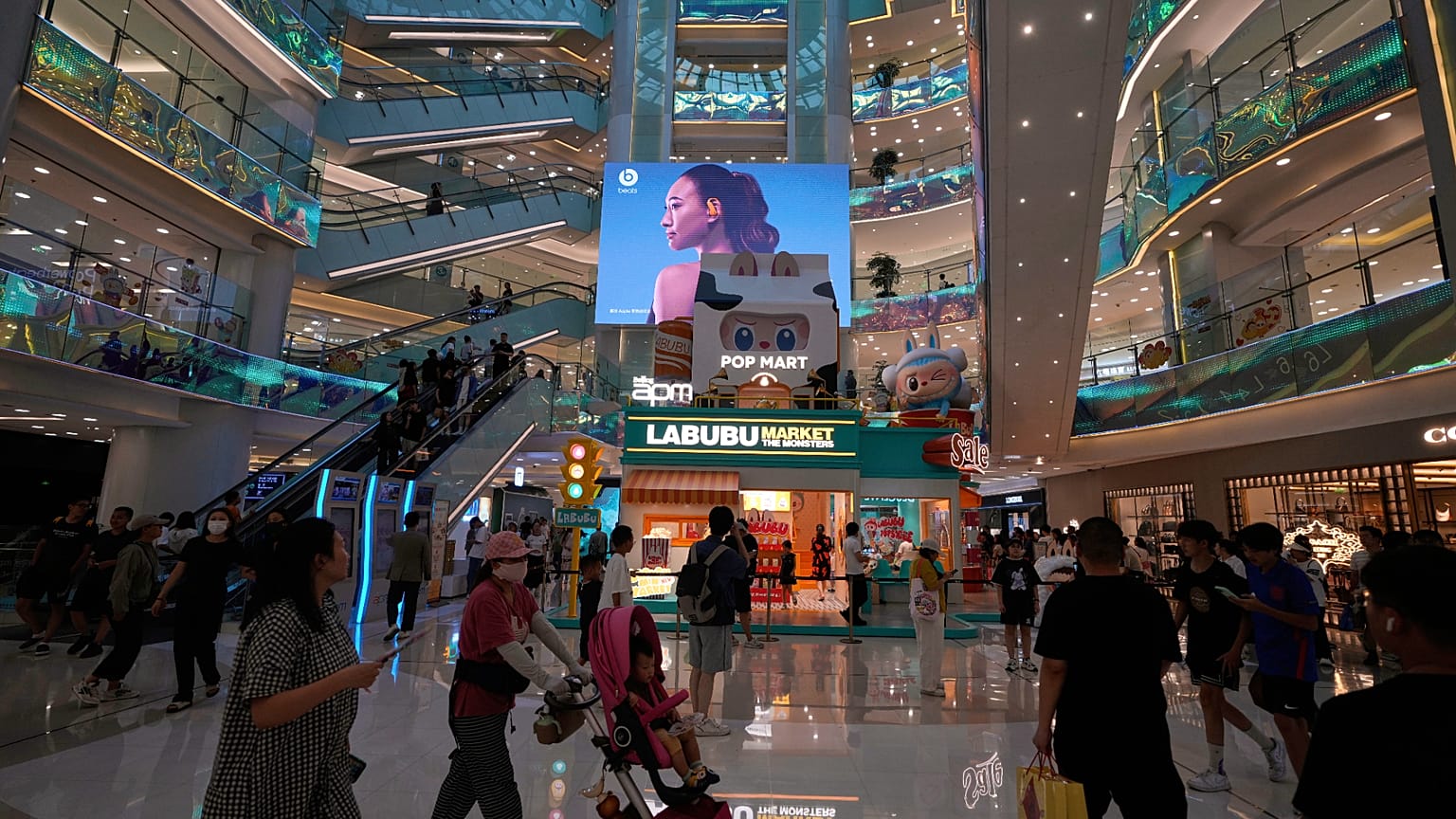 Pessoas passeiam num centro comercial em Pequim, China. 13 de julho de 2025.