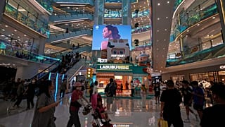 People stroll through a shopping mall in Beijing, China. 13 July 2025.