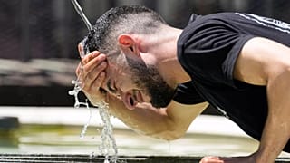 Un travailleur se rafraîchit à une fontaine pendant une vague de chaleur à Bâle, en Suisse, le 30 juin 2025.
