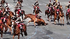 Ein Pferd rutscht auf dem Bürgersteig während der Parade zum Bastille-Tag am Montag, den 14. Juli 2025, in Paris.