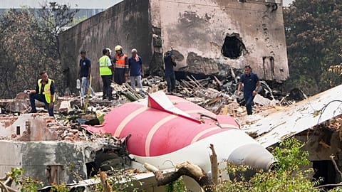 Officials inspect the site of Thursday's Air India plane crash on the roof of a building in Ahmedabad, 13 June, 2025