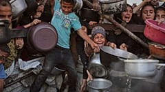 فلسطينيون يكافحون للحصول على الطعام المتبرع به في مطبخ مجتمعي في مدينة غزة، شمال قطاع غزة، يوم الاثنين 14 يوليو/تموز 2025. 