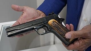 Brian Witherell exibe uma pistola Colt de calibre .45 que pertenceu ao chefe da máfia Al Capone, na casa de leilões Witherell's em Sacramento, Califórnia.