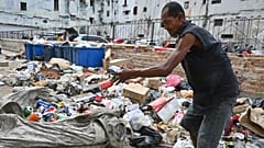 Ένας άνδρας ψάχνει στα σκουπίδια συλλέγοντας κουτιά αλουμινίου για ανακύκλωση, στην Αβάνα της Κούβας, Τρίτη 15 Ιουλίου 2025. (AP Photo/Jorge Luis Baños)