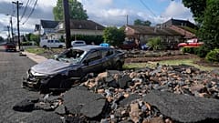Trümmer, Schutt und ein beschädigtes Auto liegen auf einer Straße nach Überschwemmungen durch Regenfälle im Gebiet von North Plainfield, New Jersey, Dienstag, 15. Juli 2025.