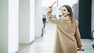 Μια γυναίκα χαιρετάει καθώς φεύγει από τη δουλειά της.