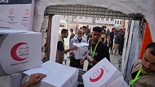 ARQUIVO: Palestinianos recebem pacotes de alimentos na cidade de Gaza, 26 de junho de 2025