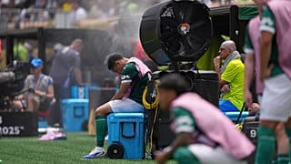 Palmeiras' Vitor Roque sits on the side of the pitch in a cooling mist after being substituted during the Club World Cup.