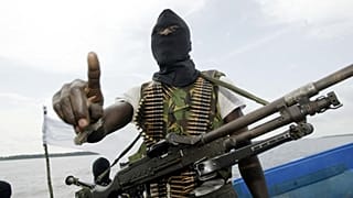 Militants wearing black masks, military fatigues and carrying Kalashnikov assault rifles patrol the creeks of the Niger Delta, 24 February, 2006