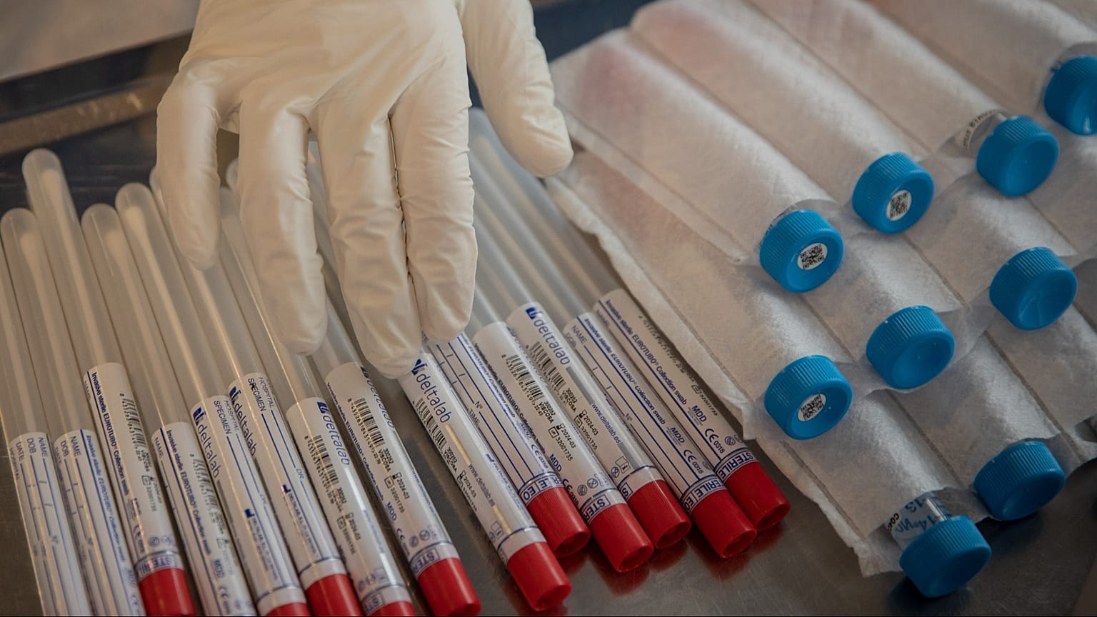 En esta fotografía del 1 de abril de 2020, un trabajador humanitario de la ONG española Open Arms toca kits de prueba de detección de coronavirus en Barcelona, España.