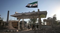 Membros da segurança carregam pertences enquanto abandonam o edifício danificado do Ministério da Defesa sírio, alegadamente atingido por vários ataques aéreos israelitas, em Damasco, Síria, quarta-feira, 1 de julho
