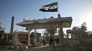 Сотрудники службы безопасности несут вещи, покидая поврежденное здание министерства обороны Сирии, предположительно пострадавшее от нескольких израильских авиаударов, в Дамаске, Сирия, среда, 1 июля.