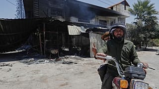 Άνδρες του συριακού στρατού περνούν μπροστά από καμμένο σπίτι Δρούζων στη Σουέιντα