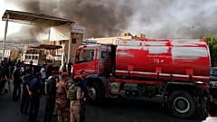 ARCHIVO: Fuerzas de seguridad iraquíes y bomberos se reúnen mientras el humo se eleva de un incendio en Bagdad, 10 de junio de 2018 - Copyright AP Photo