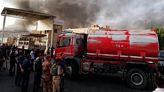 ARCHIVO: Fuerzas de seguridad iraquíes y bomberos se reúnen mientras el humo se eleva de un incendio en Bagdad, 10 de junio de 2018 - Copyright AP Photo