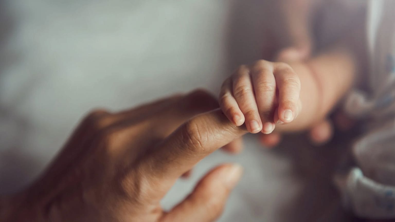 Recién nacido de la mano de su madre