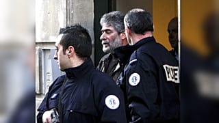 جورج إبراهيم عبد الله أثناء مغادرته محكمة الاستئناف في جنوب غرب فرنسا، برفقة شرطي فرنسي، 18 شباط/فبراير 2010.    