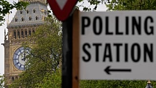 A sign points to where residents can cast their votes in London, 3 May, 2024