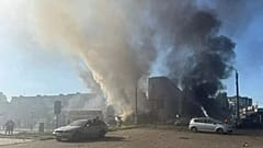 Δύο πανύψηλα σύννεφα καπνού υψώνονται από καμένα οχήματα και βιτρίνες καταστημάτων στην κεντρική Δομπροπίλια μετά από ρωσική αεροπορική επιδρομή 500 κιλών στις 16 Ιουλίου 2025.