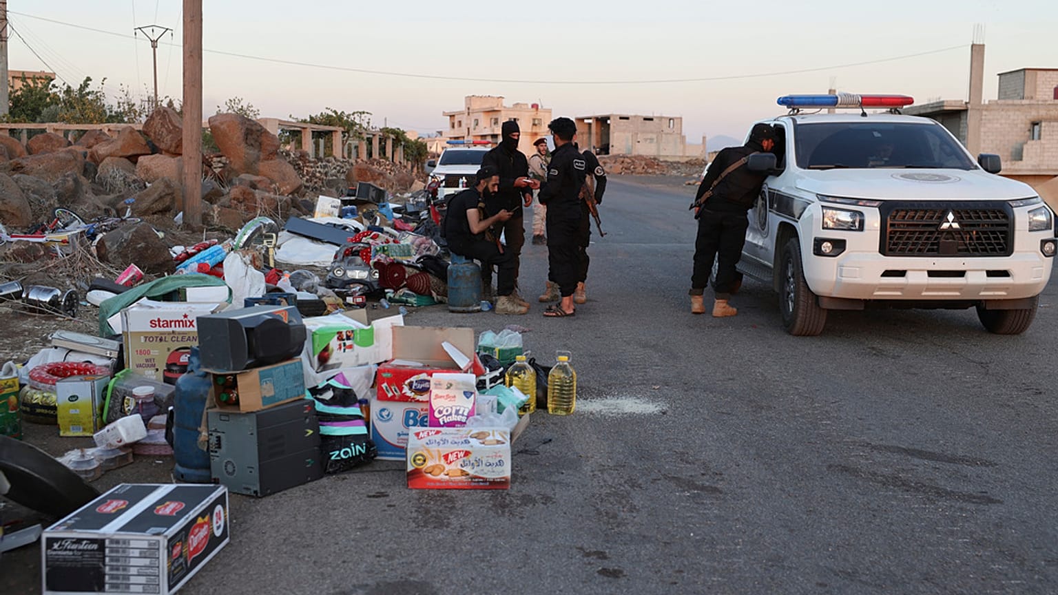 جنود حكوميون يقفون بجانب مصادرة الأشياء المسروقة خلال اشتباكات في مدينة السويداء بين القوات الحكومية والميليشيات الدرزية