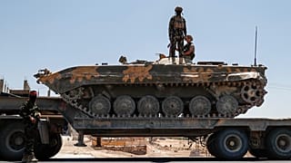 Suriye'nin geçiş hükümeti güçleri Süveyda kentinden çekilirken bir zırhlı aracın üzerinde.