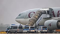 FILE: People board a Qatar Airways plane, with federal police vehicles in front of it, on the apron at Leipzig/Halle Airport, 18 July 2025.