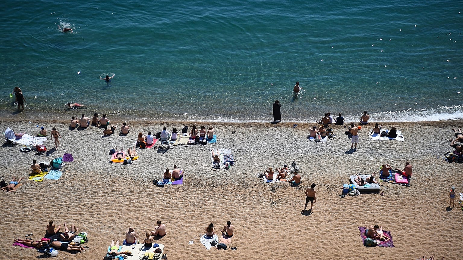 La gente disfruta del clima cálido en la playa de Durdle Door, cerca de Lulworth, en el sur de Inglaterra, el 1 de junio de 2020.