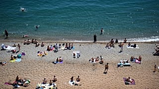 La gente disfruta del clima cálido en la playa de Durdle Door, cerca de Lulworth, en el sur de Inglaterra, el 1 de junio de 2020.