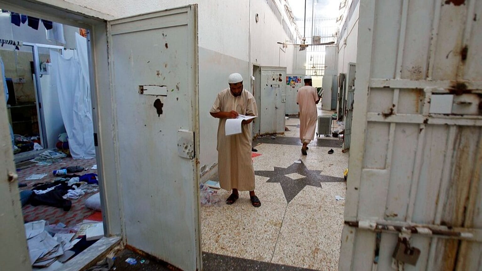 ChatGPT said: صورة أرشيفية من 27 أغسطس 2011 لمواطنين ليبيين يبحثون عن وثائق داخل سجن أبو سليم في طرابلس، أحد أشهر سجون نظام القذافي.