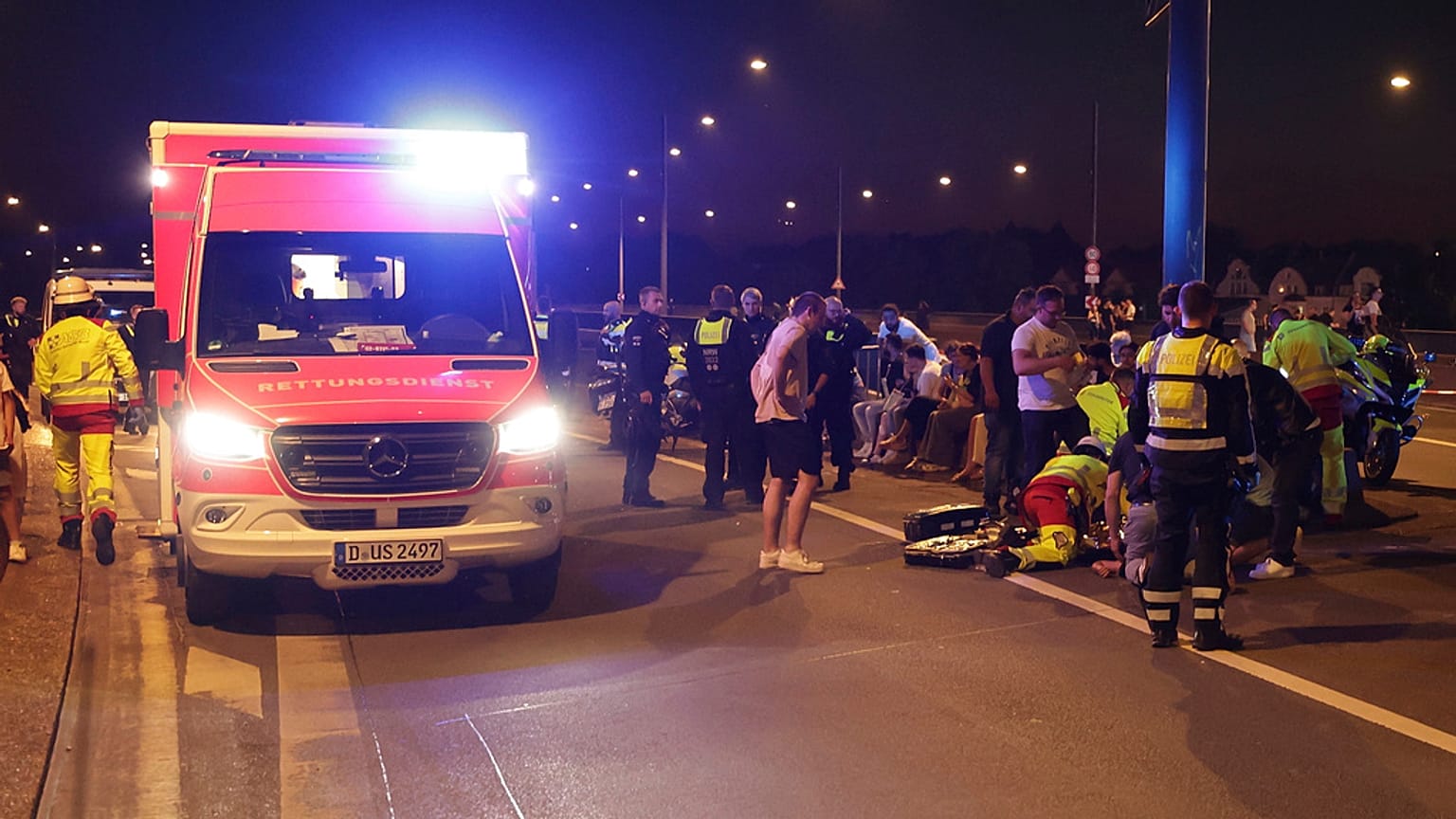 I soccorritori si occupano di persone ferite su un ponte dopo l'esplosione di fuochi d'artificio al luna park del Reno a Düsseldorf, venerdì 18 luglio 2025.