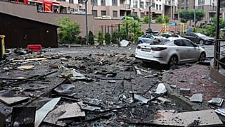 Auto danneggiate in un cortile tra altri detriti dopo un attacco russo a Kiev. Almeno quattro quartieri della capitale sono stati colpiti (21 luglio 2025)