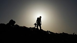 رجل فلسطيني يبحث في مكب نفايات عن الحطب والبلاستيك والمعلبات في الزوايدة، وسط قطاع غزة، الخميس 17 يوليو/تموز 2025.  