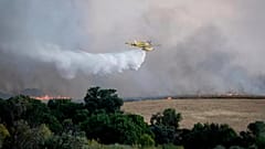 Un avión de extinción de incendios arroja agua durante los esfuerzos por extinguir un incendio forestal cerca de Navalcarnero, en Madrid, España, el 17 de julio de 2025.