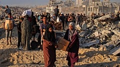 فلسطينيون يحملون أكياسا وصناديق مساعدات غذائية وإنسانية تم تفريغها من قافلة تابعة لبرنامج الأغذية العالمي كانت متوجهة إلى مدينة غزة ، شمال قطاع غزة ، الاثنين 16 حزيران / يونيو