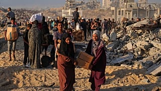 فلسطينيون يحملون أكياسا وصناديق مساعدات غذائية وإنسانية تم تفريغها من قافلة تابعة لبرنامج الأغذية العالمي كانت متوجهة إلى مدينة غزة ، شمال قطاع غزة ، الاثنين 16 حزيران / يونيو