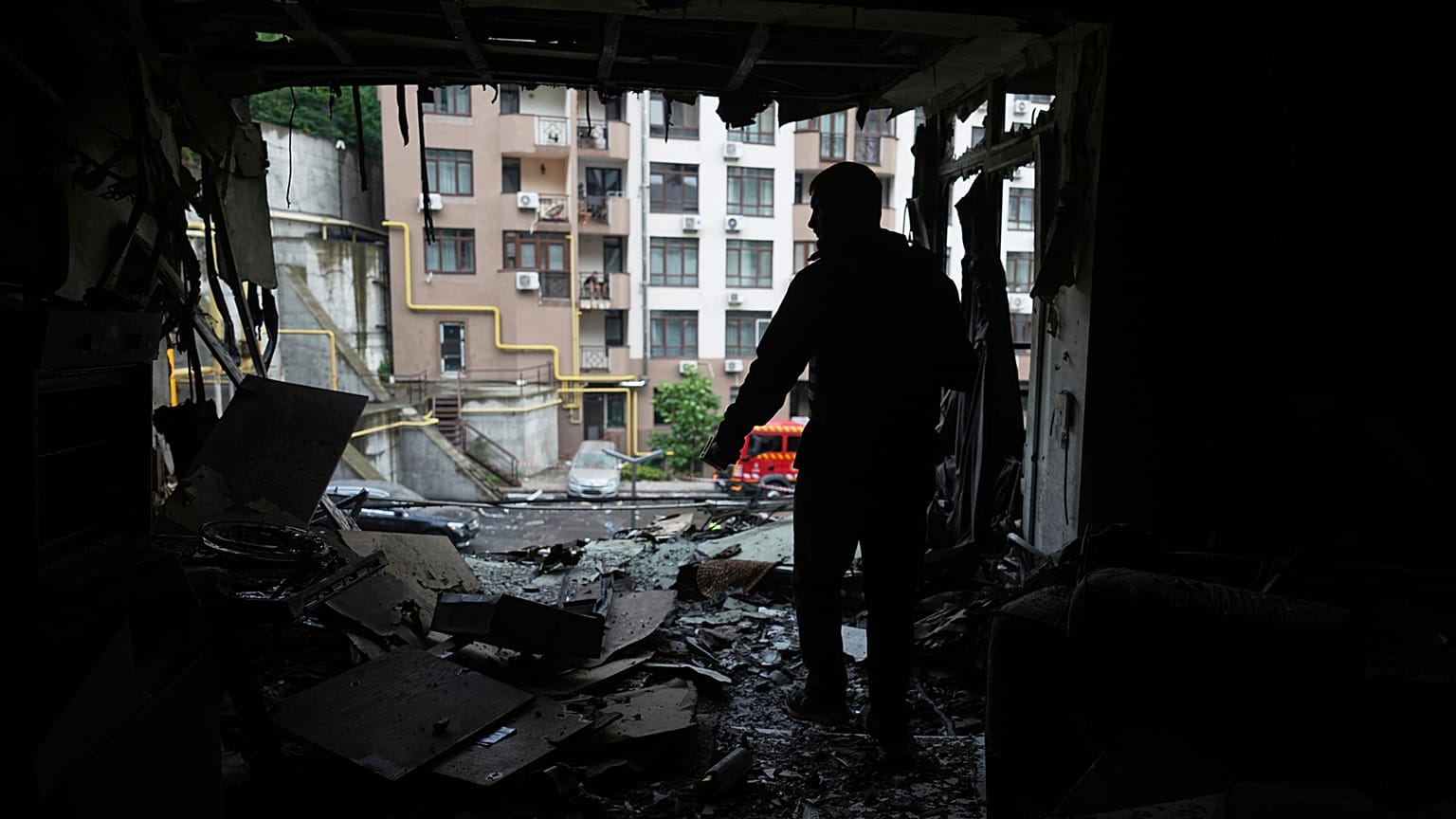 A resident stands in the damaged apartment in a multi-story house after a Russian attack in Kyiv, Ukraine, Monday, July 21, 2025.