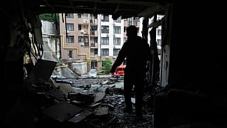 Ukrayna'nın başkenti Kiev'de 21 Temmuz 2025 Pazartesi günü gerçekleşen Rus saldırısının ardından çok katlı bir evin hasar gören dairesinde bir apartman sakini duruyor.