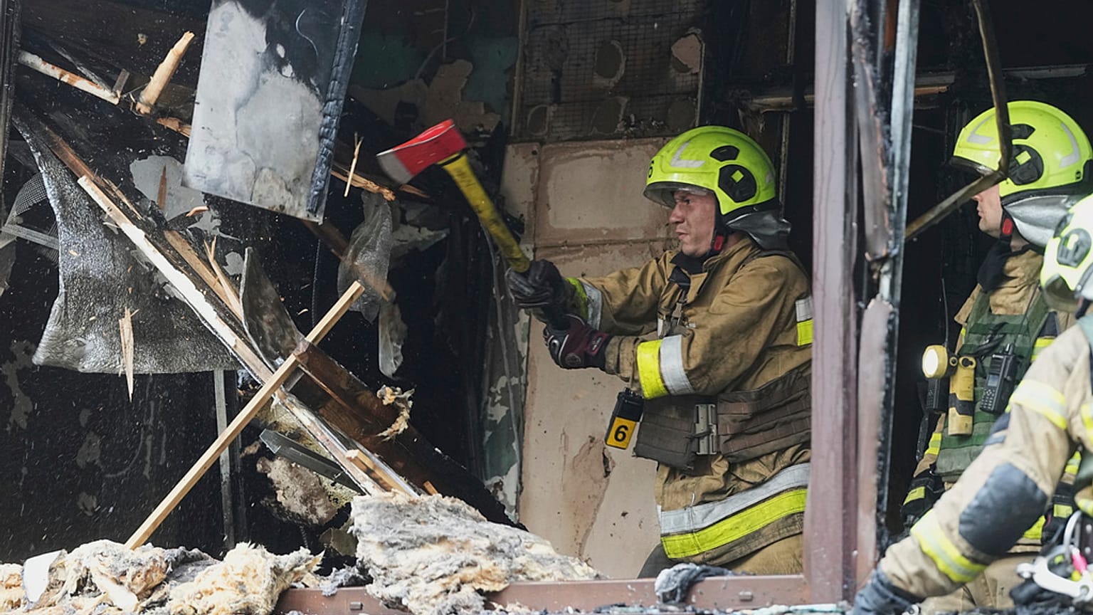 Des pompiers travaillent dans un immeuble d'habitation détruit après une attaque russe à Kyiv, en Ukraine, le lundi 21 juillet 2025.