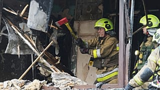 Des pompiers travaillent dans un immeuble d'habitation détruit après une attaque russe à Kyiv, en Ukraine, le lundi 21 juillet 2025.