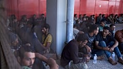Migranci na południe od Krety czekają na rejestrację po przybyciu do portu Lavrio w Grecji w czwartek 10 lipca 2025 r.