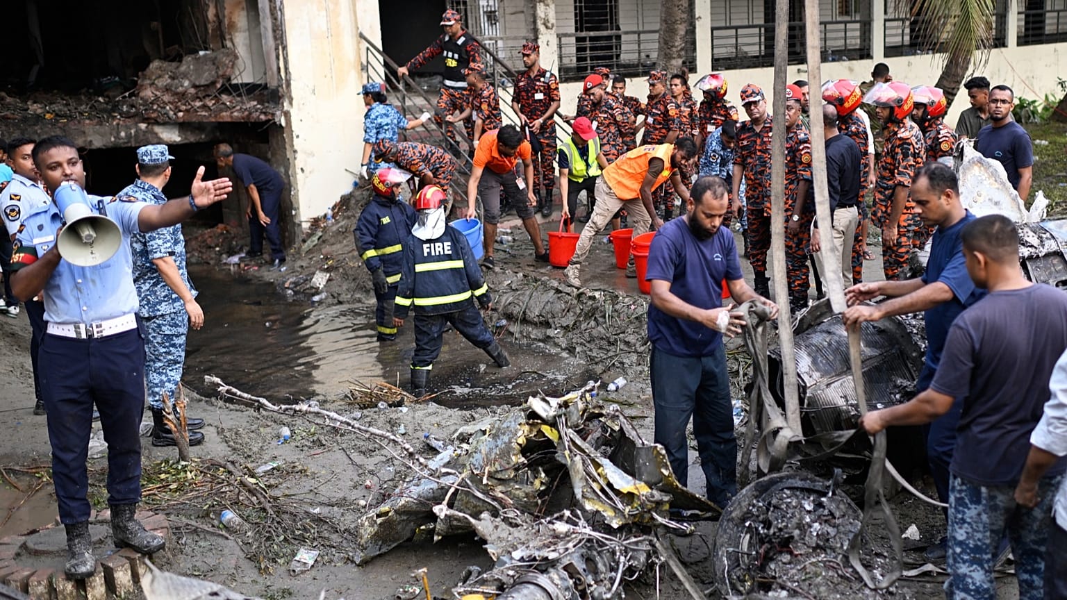 Firemen work at the site of a Bangladesh Air Force training aircraft that crashed into a school campus shortly after take-off in Dhaka, 21 July, 2025