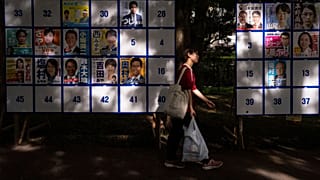 Un peatón pasa junto a un tablón electoral que muestra carteles de candidatos para las próximas elecciones a la Cámara Alta del 20 de julio en Tokio, 18 de julio de 2025.
